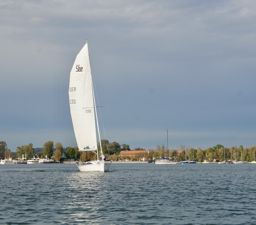 weißes Segelboot vor anderen Booten auf einem See